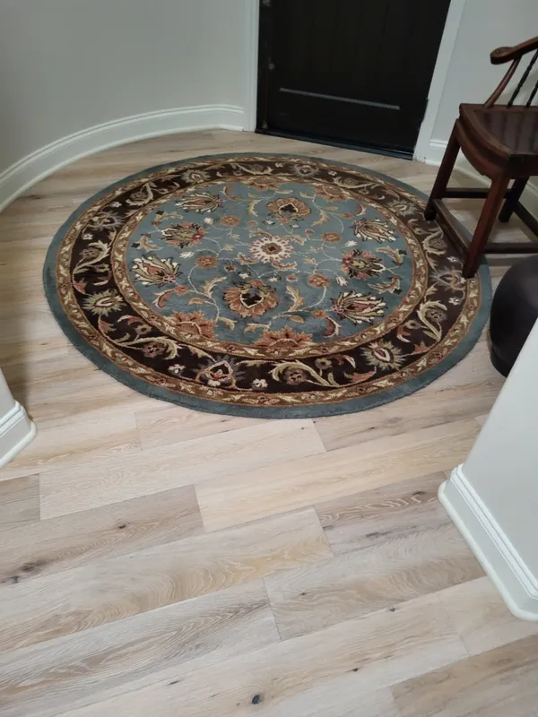 Custom round area rug placed on hardwood flooring
