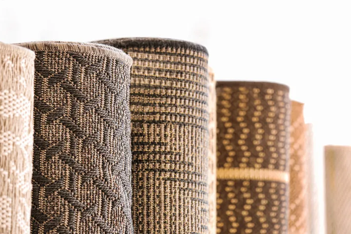Rolls of patterned area rugs standing upright in the Valley Flooring showroom